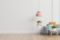 Empty living room with blue sofa, plants and table on empty white wall background.